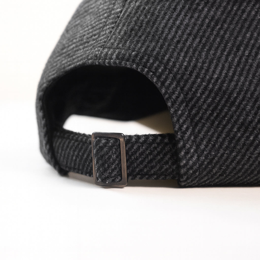 Close-up of a black cap with a textured pattern on a white background