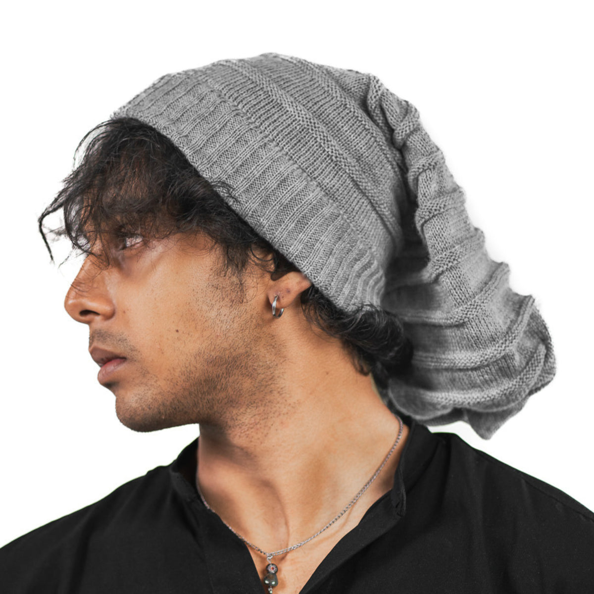 Person wearing a gray knit beanie on a white background
