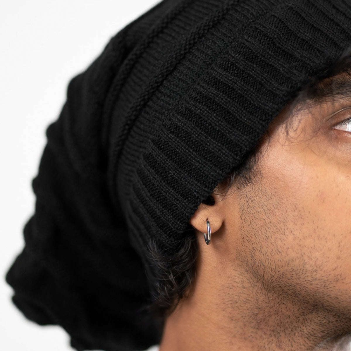 Close-up of a person wearing a black knit beanie 