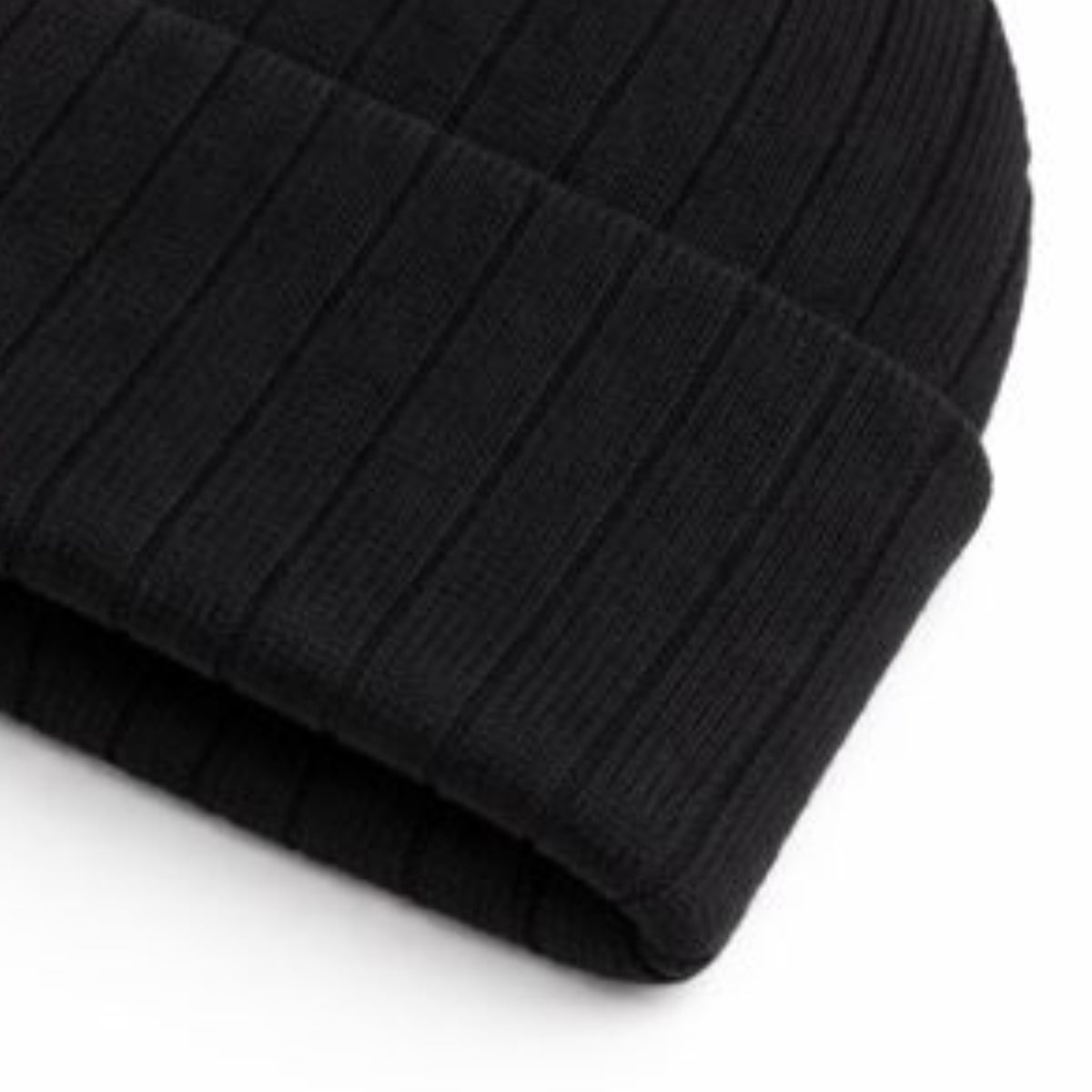 Close-up of a black knit beanie on a white background