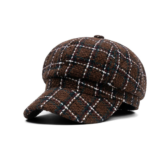 A brown wool flat cap with a white and black argyle pattern, shown in profile against a white background.